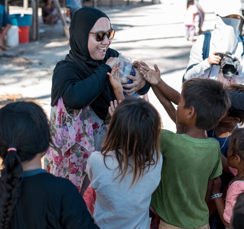 Sibuan, Malaysia - November 26, 2019: Visitors distributing snacks and goods to the Bajau Laut kids in their village.