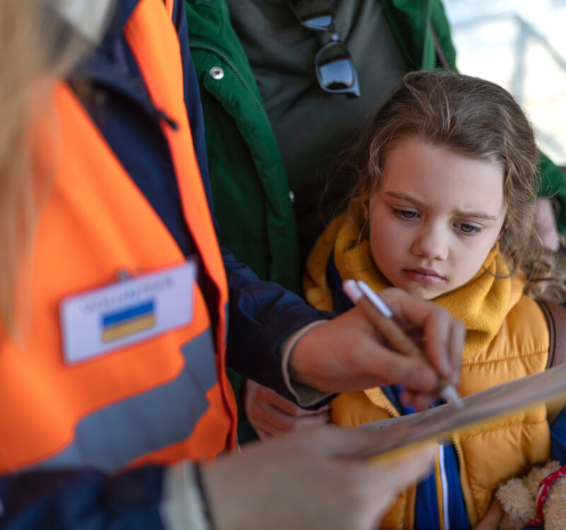 Volunteer filling form for Ukrainian refugees at train station. A volunteer registring Ukrainian refugees at train station.